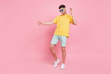 full body photo of cheerful young happy man dance wear sunglass vacation summer isolated on pink color background