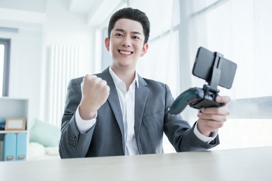 smiling young casual business man with mobile phone in the hand