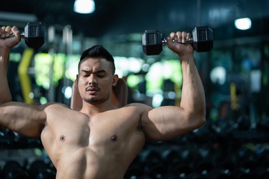 handsome adult caucasian men sweating while lift up the dumbbell workout for shoulder muscle part inside of fitness gym. bodybuilding athlete sport training for body strength and good health.