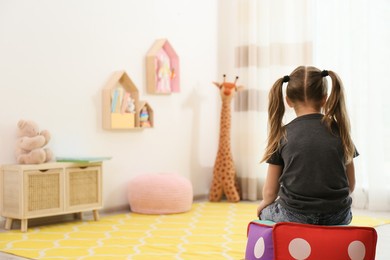 lonely little girl at home, back view. autism concept