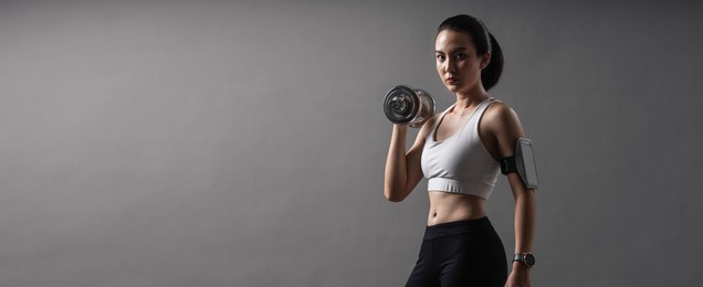 web banner portrait athlete asian active woman workout with dumbbell weightlifting up in studio grey background. young female in sportswear healthy exercise.