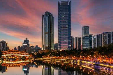 fiery red sky above the famous anshun bridge, the jinjiang river and modern skyscrapers in chengdu during a very hot summer evening