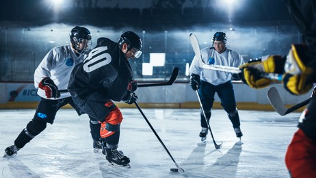 ice hockey rink arena: professional defender player attacks, pushing attacker aggressively, trying to take the puck. competitive intense game with skill, speed, energy, power.