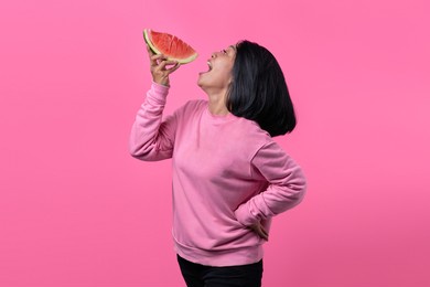 attractive young asian woman wearing sweater and holding watermelon pieces