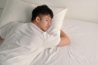 handsome young asian man sleeping in bed