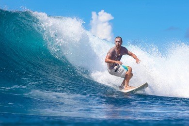 surfing a wave. lombok island. indonesia.