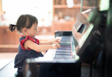 (selective focus) little asian cute girl playing piano