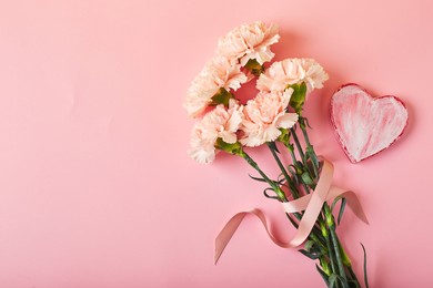 bouquet of pink carnations. design concept of holiday greeting with carnation bouquet on pink table background.