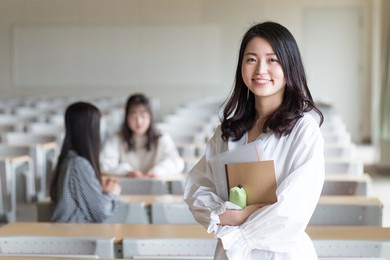 portrait of a college student standing in a lecture room