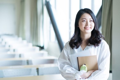 portrait of a college student standing in a lecture room