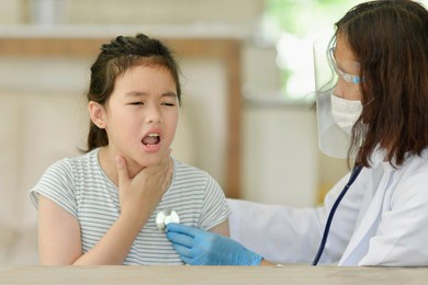asian child doing medical check up.sick kid with doctor in clinic.pediatrician examining boy's lungs with stethoscope.health care for young student.girl coughing.