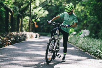 woman going to ride on bike path at park on sunny day
