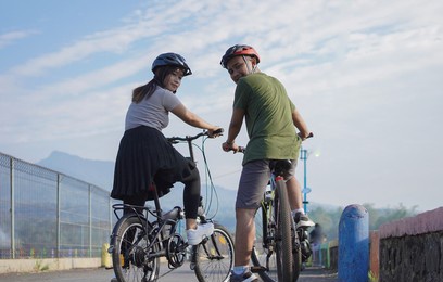 young asian couple having rest after ride bicycle 