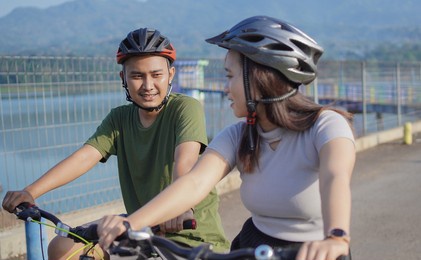 young asian couple ride bicycle in the morning