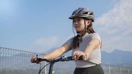 young asian woman enjoying cycling in summer morning