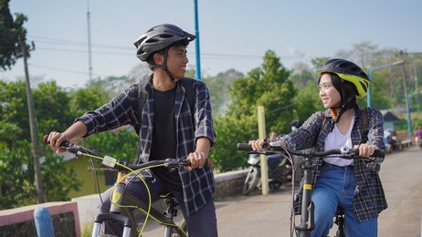 young asian couple having rest after ride bicycle go to work