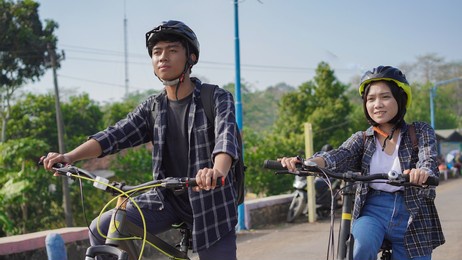 young asian couple ride bicycle together go to work