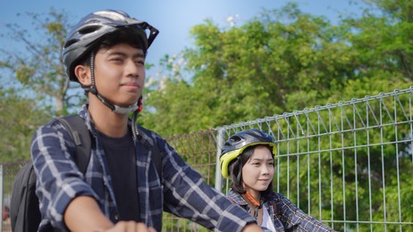 young asian couple ride bicycle together go to work