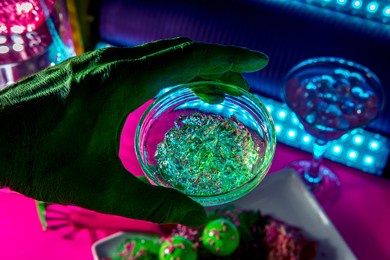 science fiction green alien from outer space eating dinner at a fancy neon nightclub