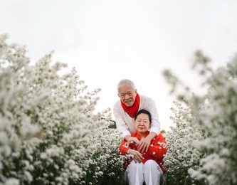 asian elder couple celebrating christmas and new year in flower garden forever love
