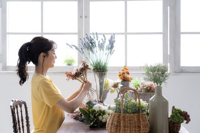 asian young woman with flower arrangement.