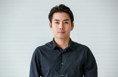 portrait of a cute young and handsome asian man in casual shirt pose to camera with warm smile and self trust.