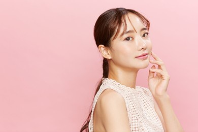 beauty portrait of young asian woman in dress on pink background.