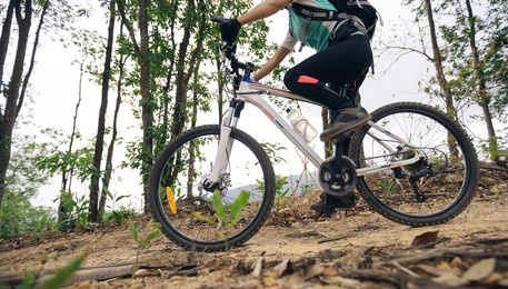 woman cyclist cycling on mountain top forest trail