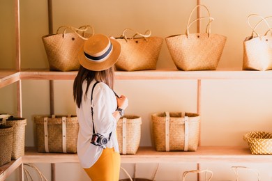traveler or blogger woman in souvenir shop, fashion stylish tourist girl looking krajood hand bags display on shelf in local handmade store, female travel phatthalung thailand, tourism beautiful asia
