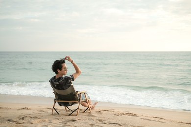 a man sitting on chair at the beach