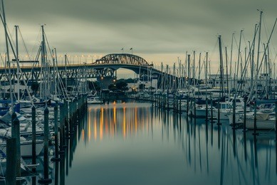 the iconic auckland harbour bridge reflecting on westhaven marina