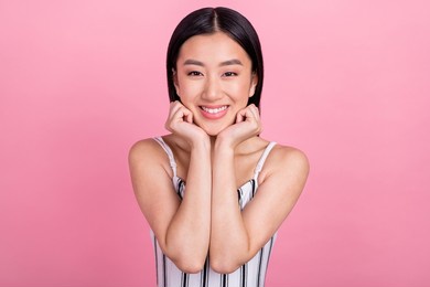 photo of adorable shiny young woman dressed white clothes smiling arms cheeks isolated pink color background