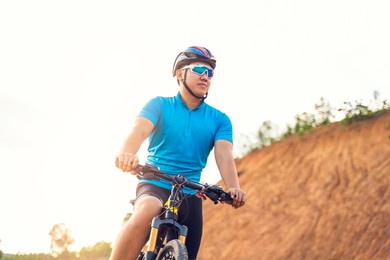mountain bikes cyclist cycling, asian man athlete riding biking on rocky terrain trail track, extreme sport wearing gear uniform helmet, exciting joy freedom outdoor nature healthy active lifestyle  
