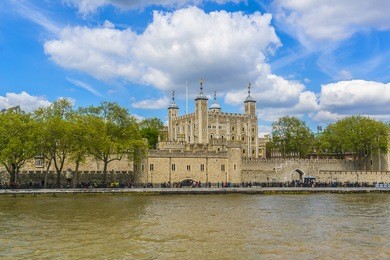 tower of london (her majesty's royal palace and fortress) - historic castle on the north bank of the river thames in central london - a popular tourist attraction. view of tower from river thames.