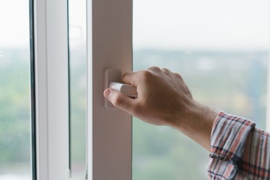 male hand opens a window