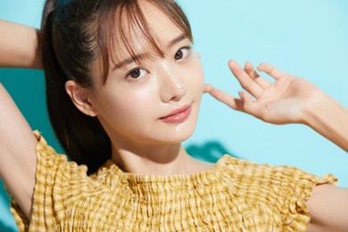 refreshing beauty portrait of a young asian woman on a blue background