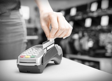 hand holding  bank terminal and plastic card