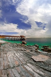 jetty by a rocky beach in pulau kapas, terengganu viewed in infrared