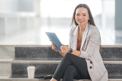 adult asian businesswoman using digital tablet computer and working outdoors office