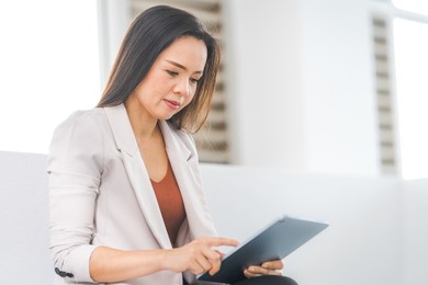 adult asian businesswoman using digital tablet computer and working outdoors office