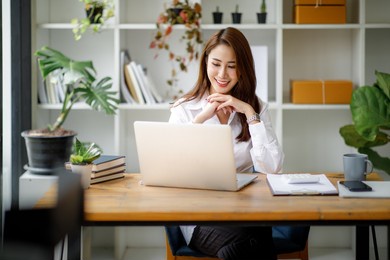 portrait of beautiful asian young business woman working audit and calculating expense annual financial report balance sheet statement,doing finance making notes on paper graph data checking document.