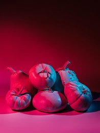 creative autumn layout made of iridescent neon luminated pumpkins and gourds. creative halloween or thanksgiving season concept. healthy and tasty food. retro futuristic vaporwave visual trend.