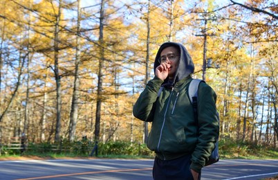 young man walking on street of autumn forest in kusatsu onsen town, japan.