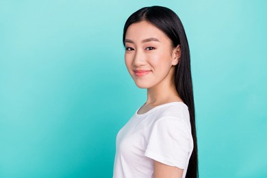 profile side photo of young attractive asian girl happy positive smile isolated over turquoise color background