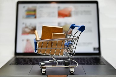miniature shopping cart on a laptop. an image of online shopping.