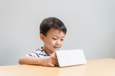 asian kid boy happy to watching smartphone cartoon. asian child and technology internet.child development.play game.excited asian little toddler is using a smartphone.video call and online learning.