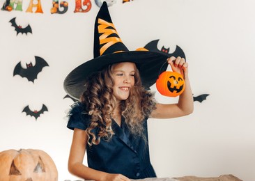little girl dressed as a witch with a pumpkin. halloween. pumpkin for halloween