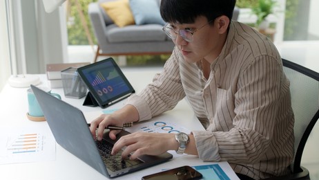 asia people happy man coding on laptop work remotely at home office sit relax smile write e-mail search data on desk. mba online study class in reskill upskill college learning for job career path.