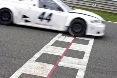 race car crossing the finish line on a circuit