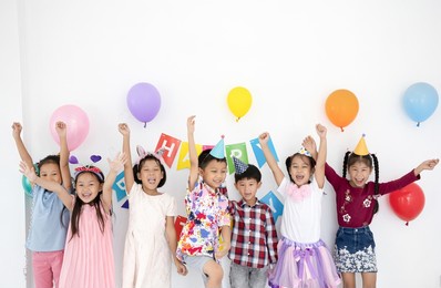 group of asian kids celebrate birthday party together in white room